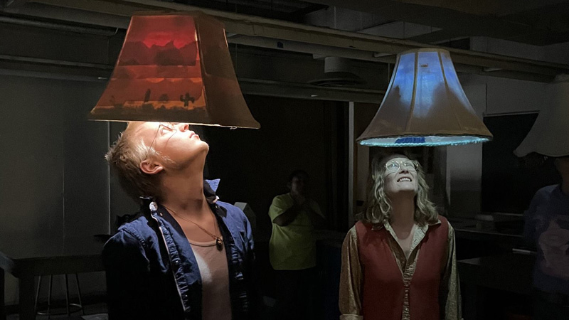two people looking up into colored lamp exhibit