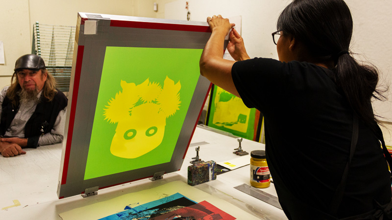 a printmaking student works in an art studio class